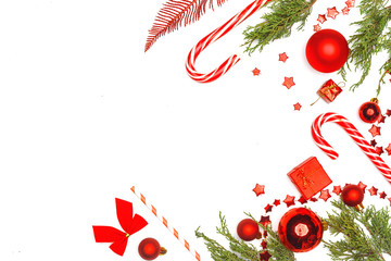 Christmas composition. Red elements of Christmas decor, decorations, sweets and fir branches on a white background.