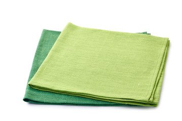 Two green folded textile napkins on white