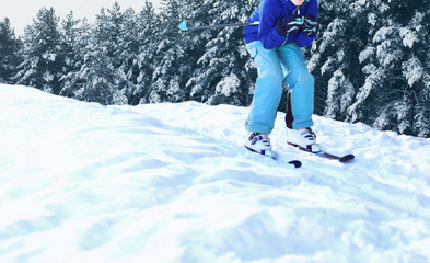 Fototapeta na wymiar skier is skiing on snow on snowy winter forest background
