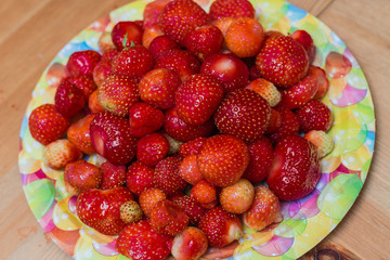 Plenty of strawberries in the plate at the  table