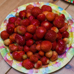 Plenty of strawberries in the plate at the  table