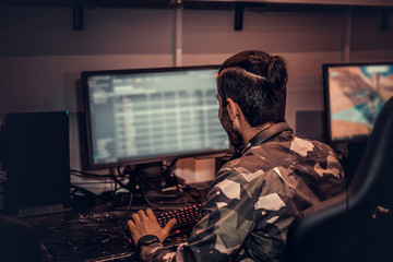 A young Indian gamer plays in a multiplayer video game on pc in a gaming club, enjoying spending time with her friends. © Fxquadro