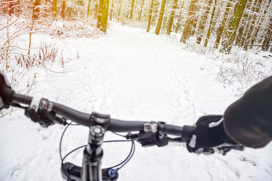 First-person view of cyclist in the winter forest. Wnter mountain bike concept