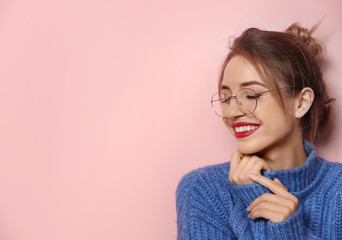 Beautiful young woman in warm sweater on color background. Space for text