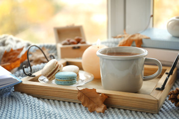Tray with breakfast near stack of books on windowsill