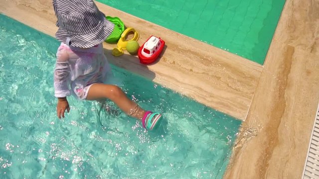 Little girl having fun in swimming pool in slow motion