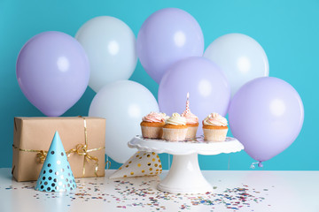 Composition with birthday cupcakes and balloons on table