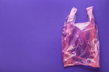 Clear disposable plastic bag on color background. Space for text