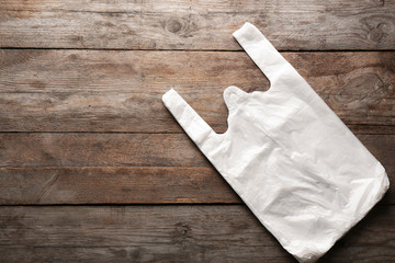 Clear disposable plastic bags on wooden background. Space for text