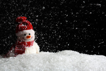 Decorative snowman on black background, space for text. Winter weather