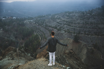 Obraz premium A young guy on the edge in the mountains