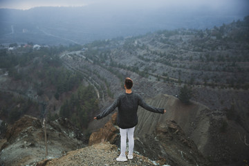 Obraz premium A young guy on the edge in the mountains