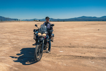 young men with motorcycle at desert