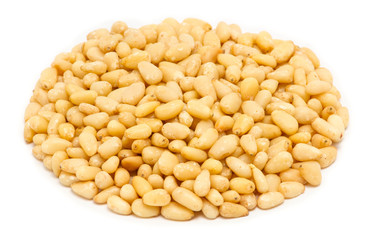 Handful of peeled pine nut kernels, close up, isolated on white background