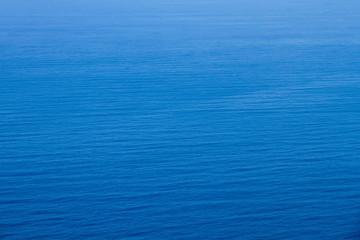 Aerial view of the clear blue sea surface on a bright sunny day.