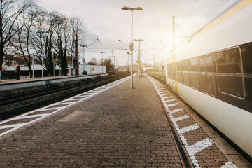 Zug fährt am leeren Bahnhof entlang
