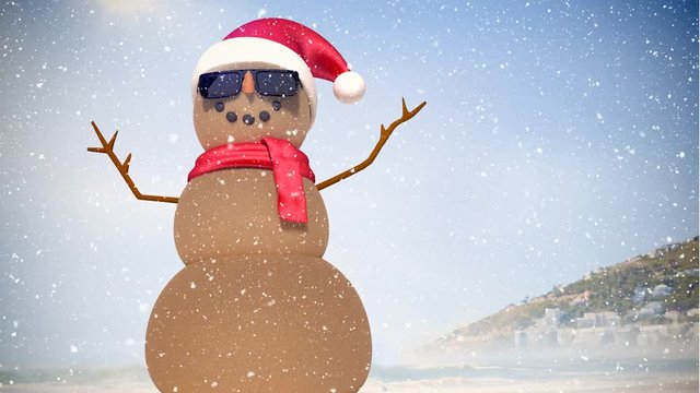 Video composition with snow over  sand man with santas hat on beach