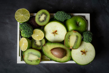 Green fresh fruits in a tray on the kitchen table. Above view