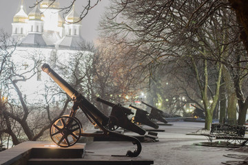 historical cannon in the snow at night