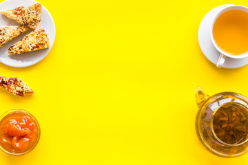 Dessert for evening tea. Cup of tea, fresh homemade cookies on yellow background top view copy space
