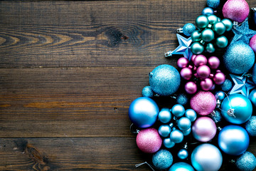 Toys for New Year tree 2019 background. Blue and pink balls and stars on dark wooden background top view copy space border
