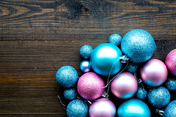 Toys for New Year tree 2019 background. Blue and pink balls on dark wooden background top view copy space border