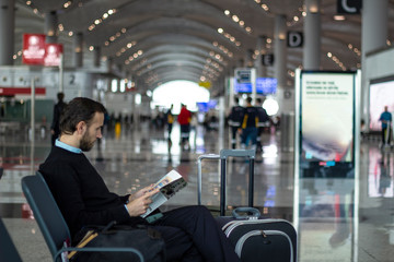 Passenger reading a magazine at the airport