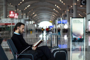 Passenger reading a book at the airport