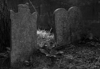 Old, worn tombstones in the corner of the cemetery. General Protestant Cemetery, St. John's, Newfoundland and Labrador, Canada.