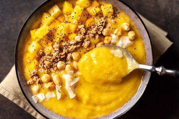 Close up of mango smoothie bowl with spoon