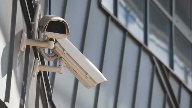 Close-up of white surveillance cameras outdoors. Video equipment near building. Privacy idea, safety, guard, concept. Nobody. Outdoors.