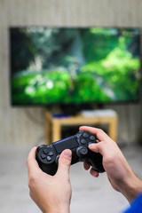 Close up view of man's hands with controller for playing video game.
