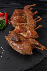 Fried quails on black table