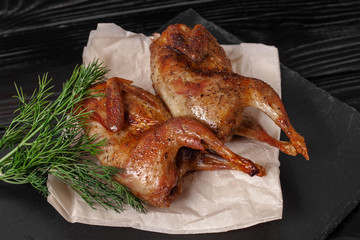 Fried quails on black table