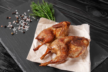 Fried quails on basalt plate