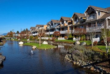 Fototapeta na wymiar New residential area in a picturesque location near a pond with a fountain in the city of Richmond