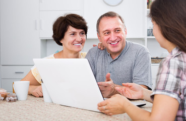 Daughter showing documents on computer to  parents
