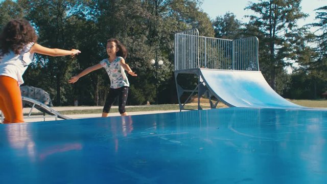 Girls kids are riding roller blades skating in a playground, 4k slow motion