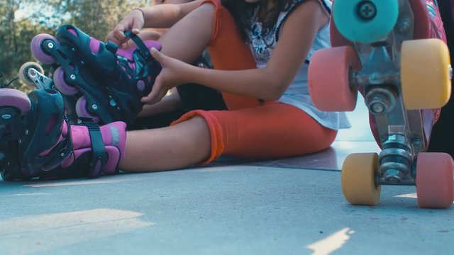 Girls kids prepare to ride roller blades skating in a playground, 4k slow motion