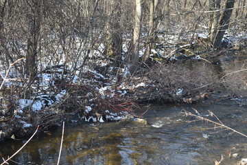 Winding river creek in a rural area in early winter light snow
