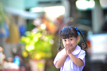 cute Asian school girl in action of Thai greeting style. Thai greeting meaning is to say...