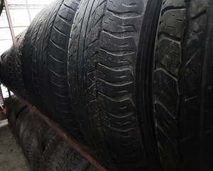 row of worn tires on a rack in the garage