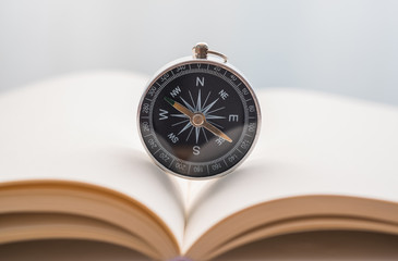 Compass on notebook on the table with blurred background. Close-up Compass.