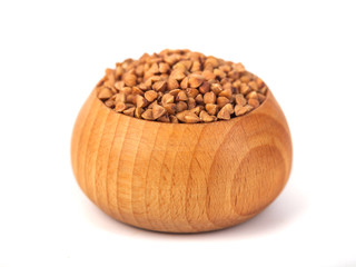Roasted buckwheat grains in wooden bowl isolated on white background with clipping path