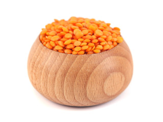 Red lentils in the wooden bowl isolated on white backgroun