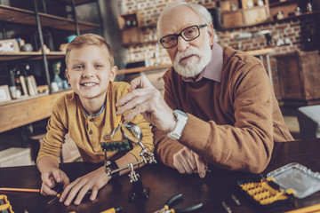 Handsome boy sitting near his grandfather