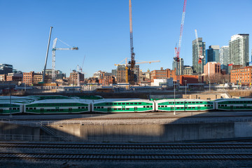 Toronto, Canada – December 4th 2018 view of the railroad tracks with a group GO green wagon trains to the entrance of the business center of Toronto