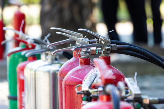 Close up Fire Safety Set Different Types of Extinguishers Placed outdoors for staff training.