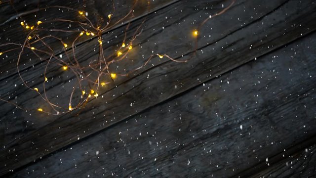 Falling snow with Christmas lights on wood