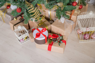 Fototapeta na wymiar Presents and Gifts under Christmas Tree, Winter Holiday Concept.gift boxes wrapped in craft paper with satin red ribbon bow for christmas present box,celebration surprise on wooden background, copy